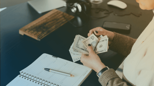 una persona contando billetes de dolar