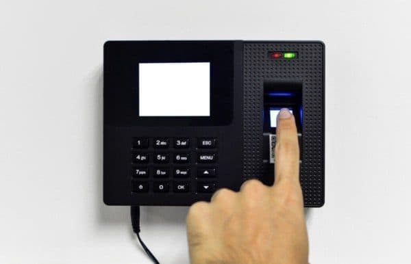 Dedo índice sobre lector de huellas dactilares de un reloj control.