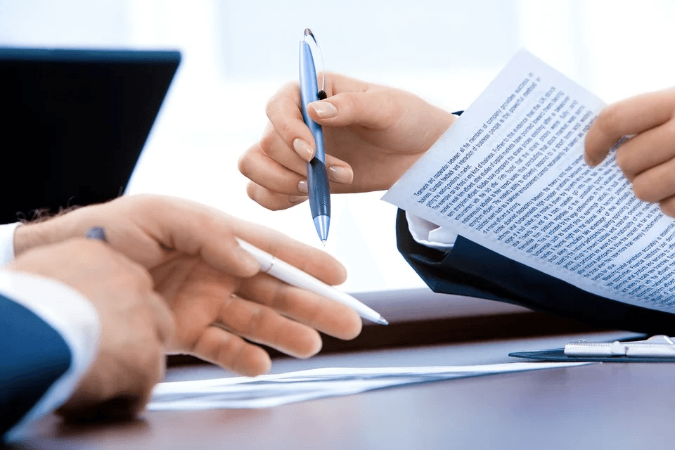 Empleador y empleado firmando un contrato.