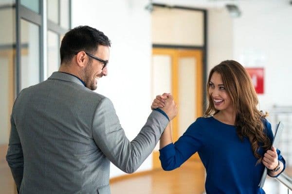 Personas de una empresa estrechan sus manos en señal de compañerismo.
