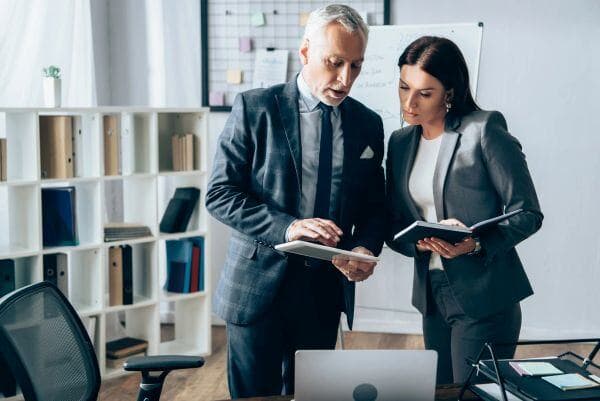 Empleado y empleador viendo una planilla sobre ausentismo laboral