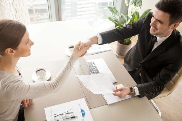 Personas estrechan su mano para cerrar el acuerdo por anexo de contrato.