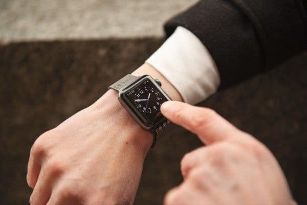 Primera plano de mujer mirando el tiempo en su reloj de pulsera.
