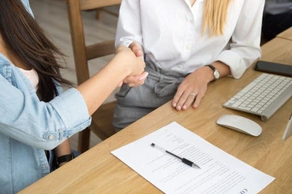 personal de recursos humanos estrecha su mano a trabajadora que cumple con el artículo 42 ley federal del trabajo.
