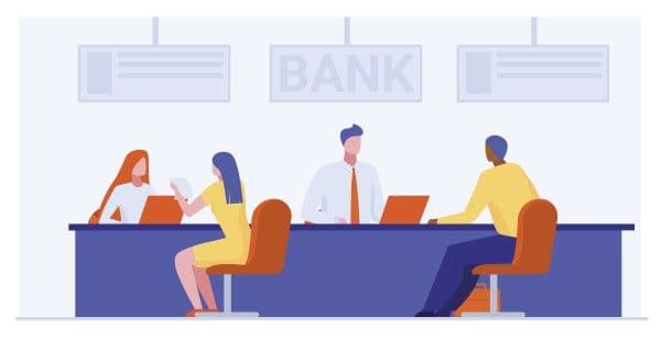 Trabajadores bancarios que prestan servicios a clientes.