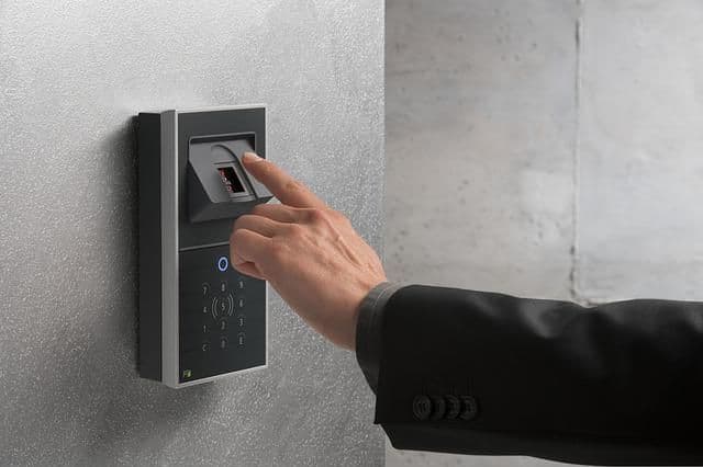 Persona accediendo a un edificio con un lector biométrico.