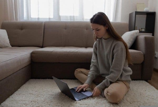Mujer trabajando desde el living de su casa.
