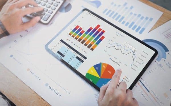Persona manipulando una tablet con gráficos de rendimiento.
