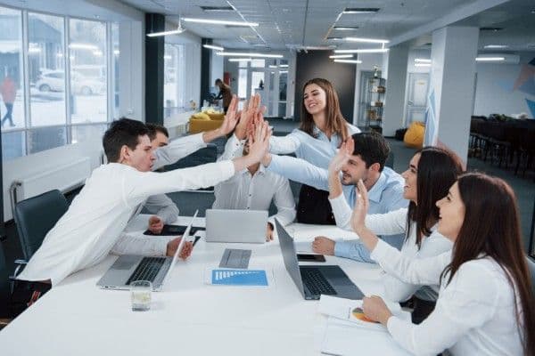 personas en empresa saludándose de forma amistosa.