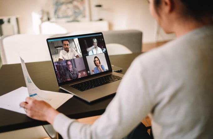 Mujer usa su laptop para una videoconferencia con cuatro compañeros de trabajo.
