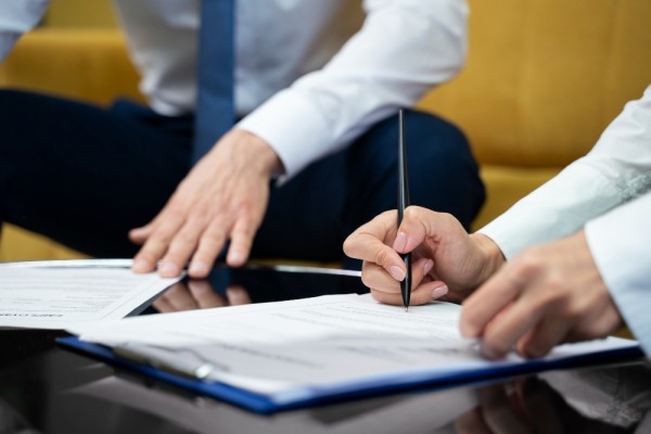 Primer plano de una persona firmando el término de su contrato laboral.