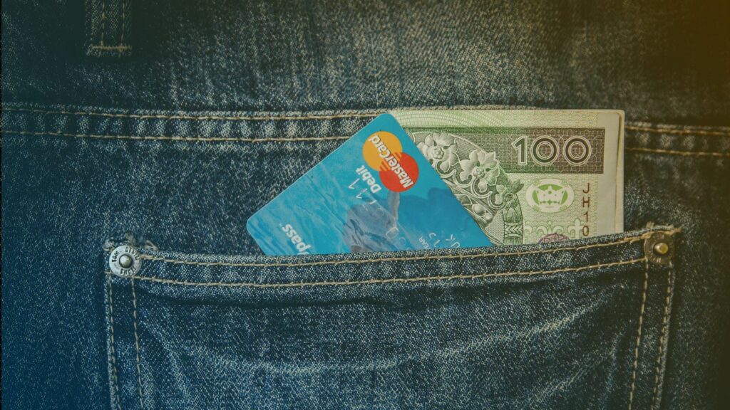 Bolsillo de un pantalón con una tarjeta de crédito y dinero.