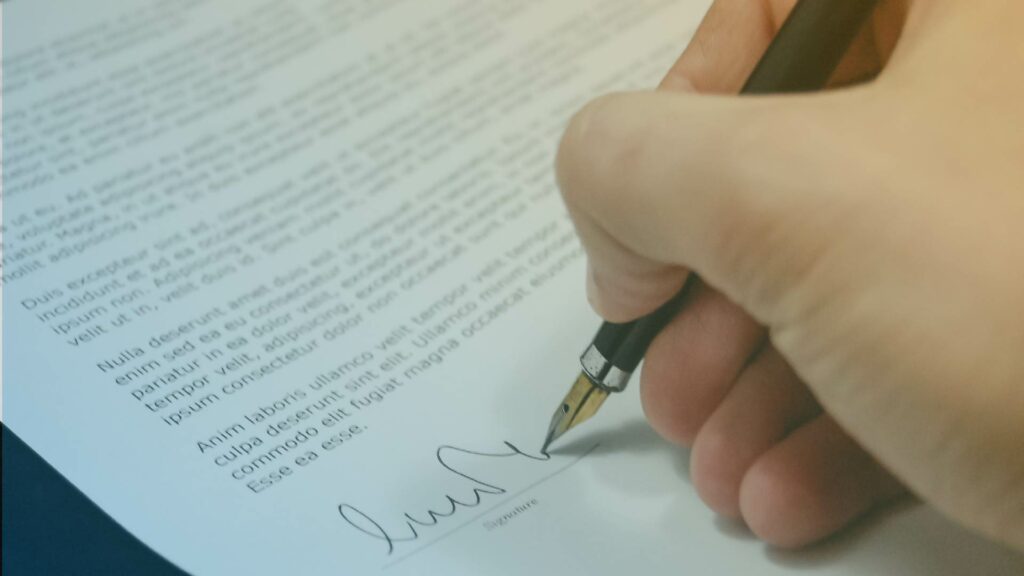 Persona firmando un documento.