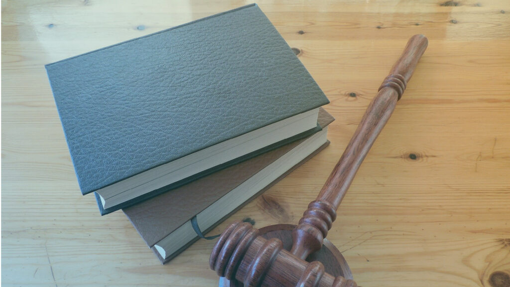 Libros jurídicos y mazo sobre una mesa.