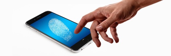 mano sobre el lector de huella dactilar por biometría de un teléfono inteligente .